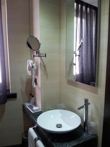 a bathroom with a sink and a mirror at Hotel Excelsior in La Maddalena