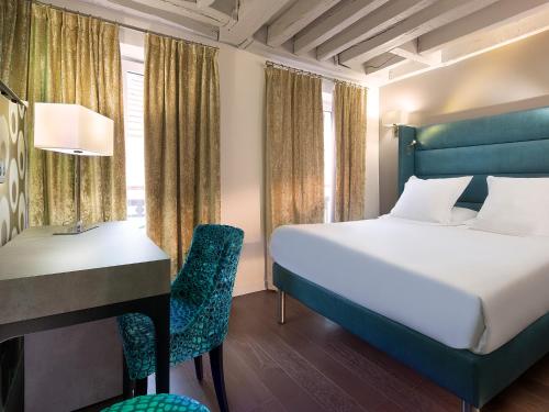 a hotel room with a bed and a desk and a bed and a deskonnaissance at Hôtel Jacques De Molay in Paris