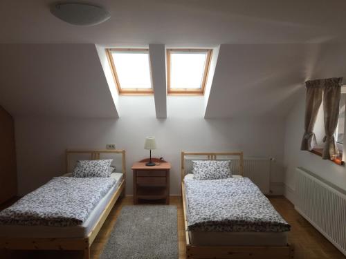 two beds in a room with two windows at Apartments Vila Cvetka Bled in Bled