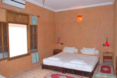 a bedroom with a bed and a window at Gite Souss in Oulad Teima