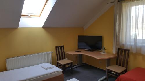 Habitación con escritorio, TV y cama. en Zajazd Gosciniec, en Łańcut