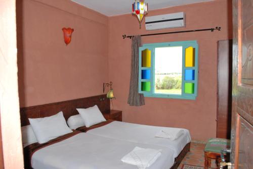 a bedroom with a bed and a window at Gite Souss in Oulad Teima