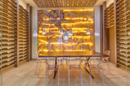 a dining room with a table and chairs and a wall of wine racks at Royalton Negril, An Autograph Collection All-Inclusive Resort in Negril