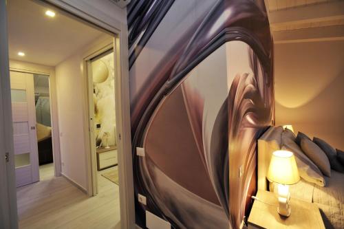 ein Schlafzimmer mit einem Bett mit einem großen Gemälde an der Wand in der Unterkunft Luxury Apartment Della Marca in SantʼAntonio Abate