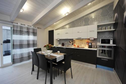 cocina y comedor con mesa y sillas en Luxury Apartment Della Marca, en SantʼAntonio Abate
