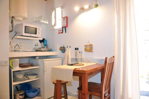 a small kitchen with a table and a refrigerator at 16 Porto Santo Apartments in Porto Santo