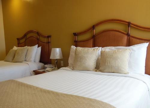 two beds with white pillows in a hotel room at Radisson Colon 2,000 Hotel & Casino in Colón
