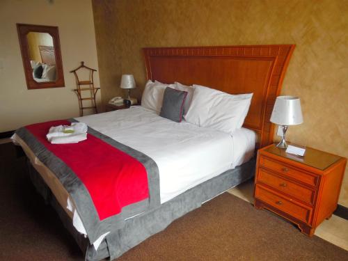 a bedroom with a large bed with a red blanket on it at Radisson Colon 2,000 Hotel & Casino in Colón
