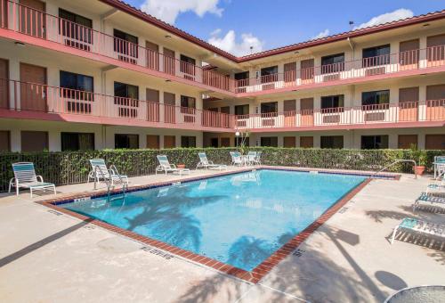 a large swimming pool in front of a hotel at Inn of America in Palm Beach Gardens