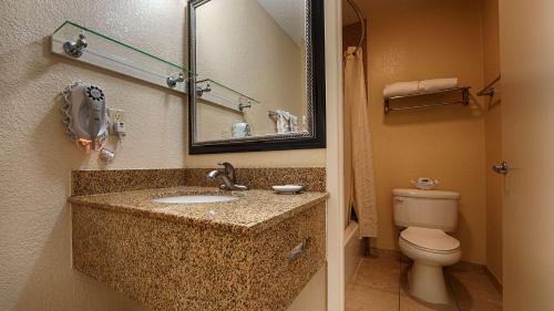 a bathroom with a sink and a toilet and a mirror at Best Western Poway/San Diego Hotel in Poway