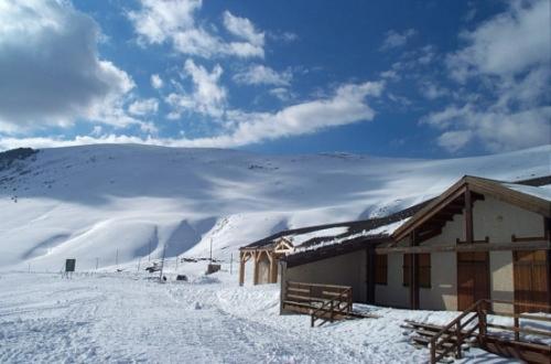 a building in the snow next to a mountain at La Galisesagnoise in Briançonnet