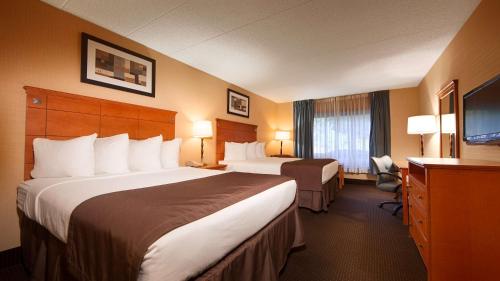 a hotel room with two beds and a television at Best Western Danbury/Bethel in Bethel