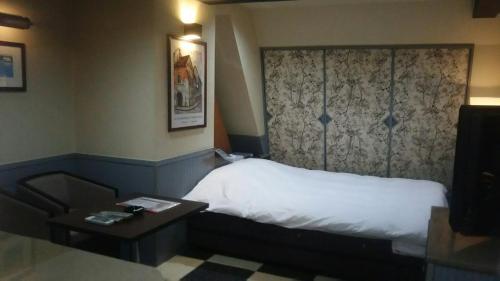 a hotel room with a bed and a table at Hotel Sting in Tokyo