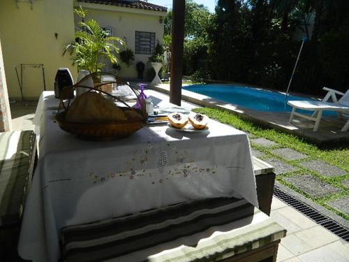 a table with a basket of food on it next to a pool at Casa Santa Teresa B&B in Rio de Janeiro