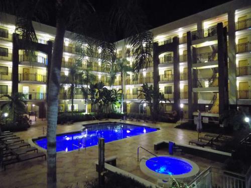 a hotel with a pool in front of a building at night at Best Western Plus Deerfield Beach Hotel & Suites in Deerfield Beach