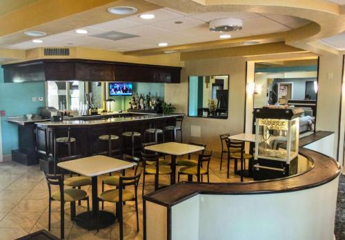 a bar with tables and chairs in a restaurant at Best Western Plus Deerfield Beach Hotel & Suites in Deerfield Beach