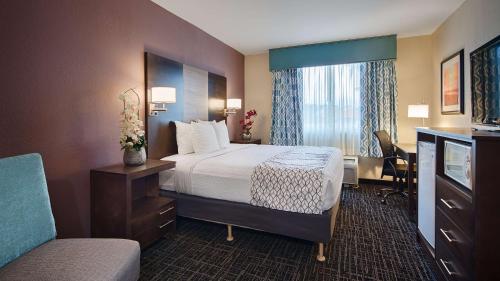 una camera d'albergo con letto e sedia di Best Western Fort Myers Inn and Suites a Fort Myers