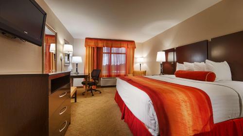 Habitación de hotel con cama grande y escritorio. en Best Western Plus Jacksonville West en Jacksonville