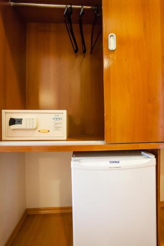 a microwave sitting on top of a refrigerator in a kitchen at Leques Brasil Hotel Escola in Sao Paulo