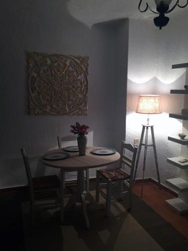 a dining room with a table and chairs and a lamp at Porto Maltese Boutique Estate in Agios Nikolaos