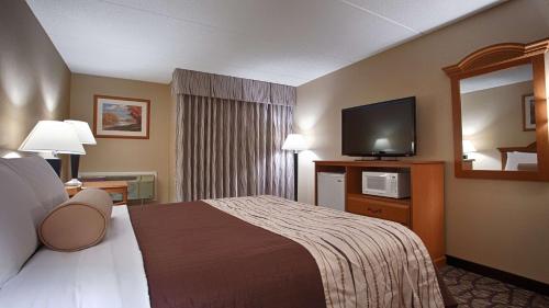 a hotel room with a bed and a flat screen tv at Best Western Clifton Park in Clifton Park