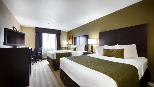 a hotel room with two beds and a flat screen tv at Best Western Norwalk in Norwalk