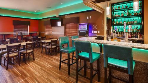 a bar in a restaurant with tables and chairs at Best Western Plus Edinburg Inn & Suites in Edinburg