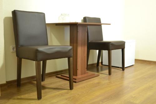 a table with two chairs and a table with a desk at Tihe Noci Motel in Pale