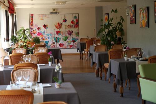 une salle à manger avec des tables et des chaises dans un restaurant dans l'établissement La Cascade, à Mouthier-Haute-Pierre