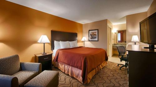 a hotel room with a bed and two chairs at Best Western Lake Conroe in Montgomery