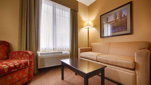 a living room with a couch and a table in a hotel room at Best Western Plus Port of Camas-Washougal Convention Center in Washougal