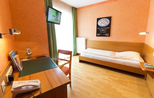 Una televisión o centro de entretenimiento en An der Persiluhr Stadt-gut-Hotel