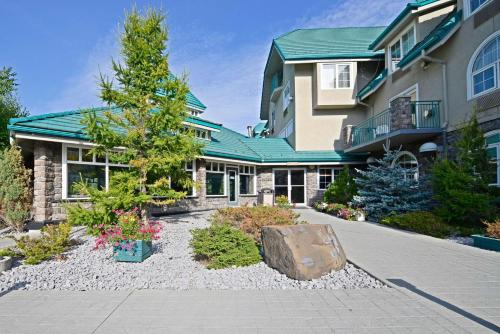 a house with a garden in front of it at Pocaterra Inn & Waterslide in Canmore