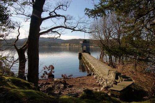 a bridge over a body of water with trees at Storrs Hall Hotel on the shore of Lake Windermere in Bowness-on-Windermere