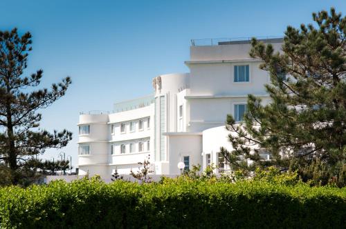 ein weißes Gebäude mit Bäumen davor in der Unterkunft Midland Hotel in Morecambe