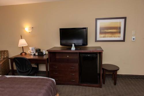 a living room with a television and a bed at Best Western Maple Ridge in Maple Ridge