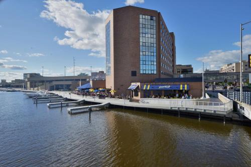 a river with a building and a pier with a building at Oshkosh Waterfront Hotel & Convention Center in Oshkosh