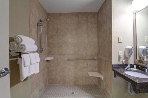 a bathroom with a shower and a sink at Best Western Plus Bowmanville in Bowmanville