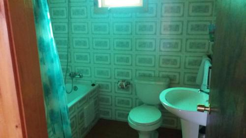 een badkamer met een toilet, een bad en een wastafel bij Cabanas Neptuno in Quellón