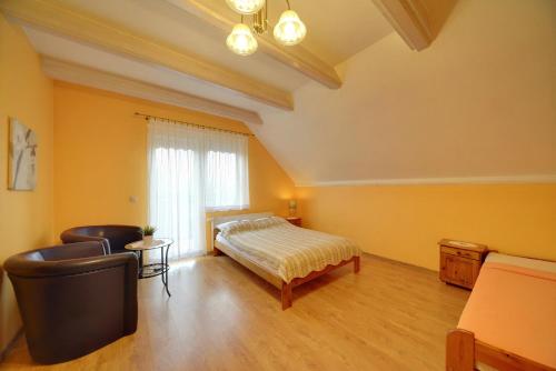 a bedroom with a bed and a chair and a window at Willa pod Czantorią SPA Ustroń in Ustroń
