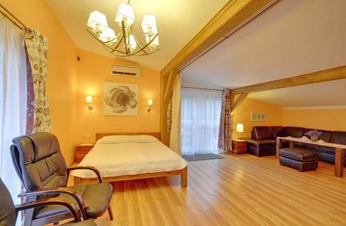 a bedroom with a bed and a living room at Willa pod Czantorią SPA Ustroń in Ustroń