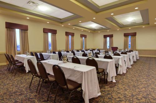 a banquet hall with white tables and chairs and windows at Best Western Plus Winnipeg Airport Hotel in Winnipeg
