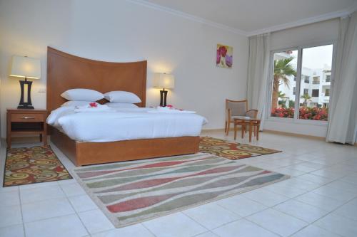 a bedroom with a large bed and a large window at Old Vic Sharm Resort in Sharm El Sheikh
