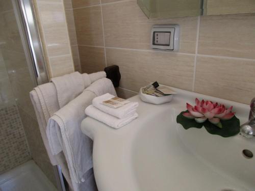 La salle de bains est pourvue d'une baignoire avec une fleur. dans l'établissement B&B Santa Sofia, à Gravina di Catania