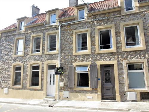 an old stone building with a door on a street at p'tite maison entre mer et campagne in Wimille
