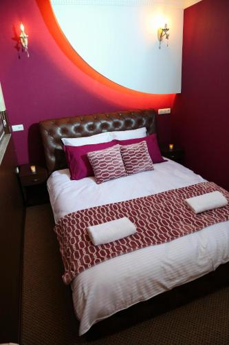 a bedroom with a large bed with purple walls at Hotel OK in Prizren