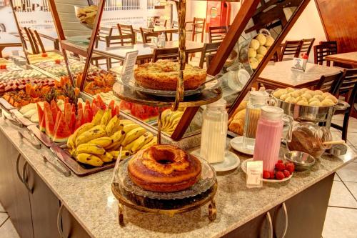 a buffet with many different types of food on a counter at Hotel Vela Azul in Balneário Camboriú