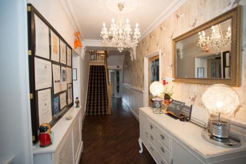 a room with a white dresser and a mirror at Holly Lodge Guest House with FREE off site health club in Windermere