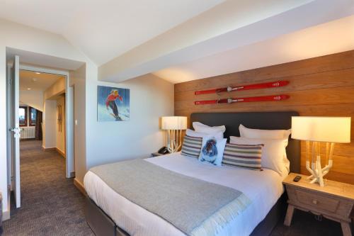 a bedroom with a large bed with a wooden wall at La Mainaz Hôtel Restaurant Genève - Gex - Mijoux in Gex