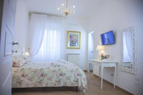 1 dormitorio con cama, mesa y espejo en La Perla - Chic Accommodation, en Sassari